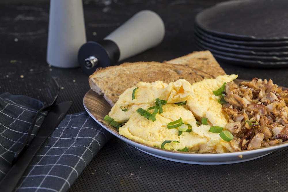 a plate of eggs, toast, and meat on a table