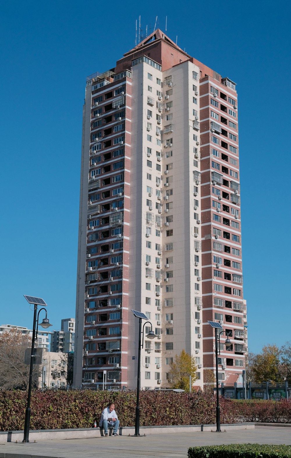 two people sitting on a bench in front of a tall building