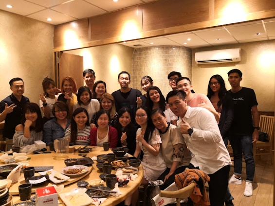 A diverse group sharing a meal around a cozy kitchen table, smiling and connecting warmly.