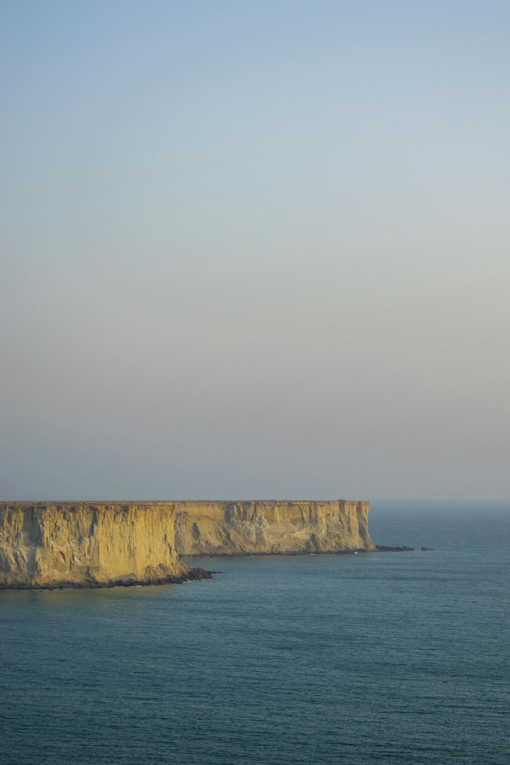 a large body of water sitting next to a cliff