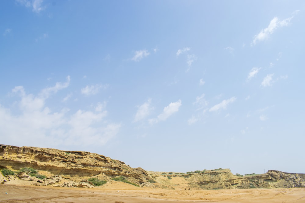 a sandy hill with a blue sky in the background