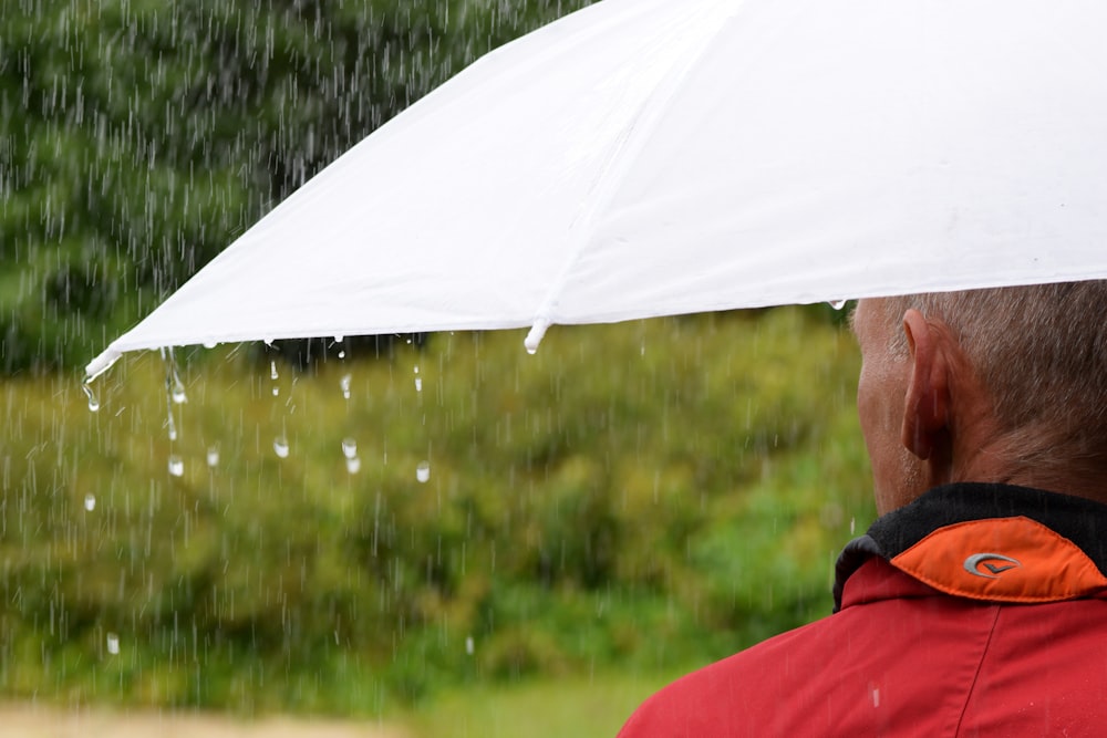 Ein Mann hält einen Regenschirm im Regen