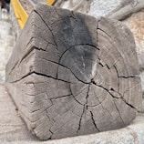 Side-by-side images displaying a weathered wooden beam transformed by aerogommage.