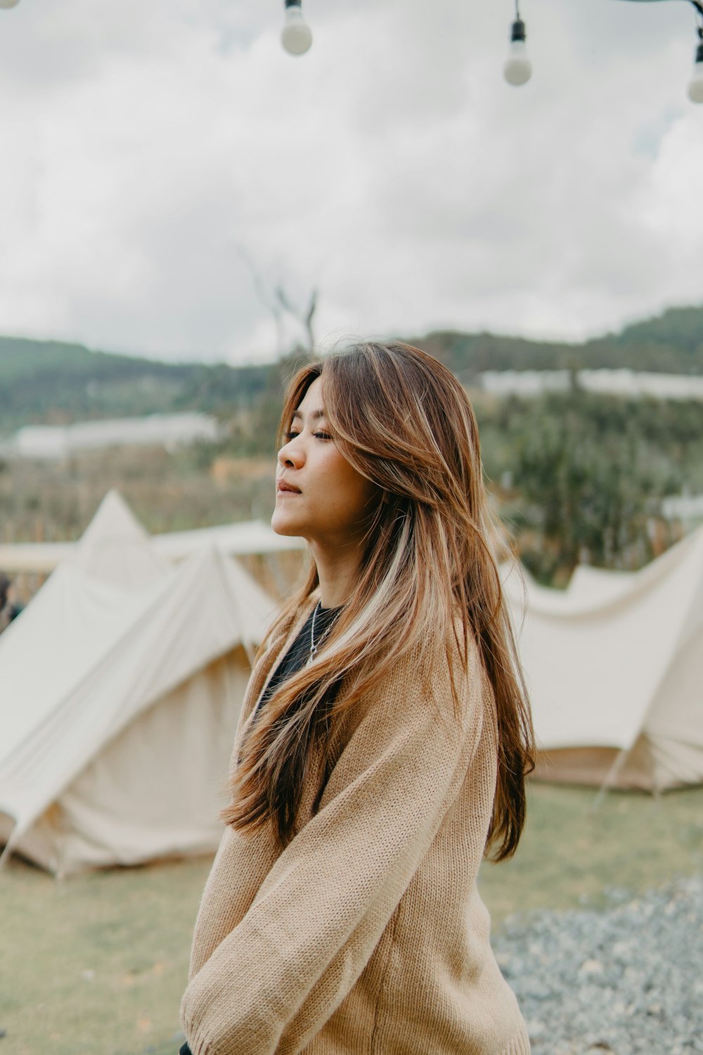 a woman standing in front of a group of tents