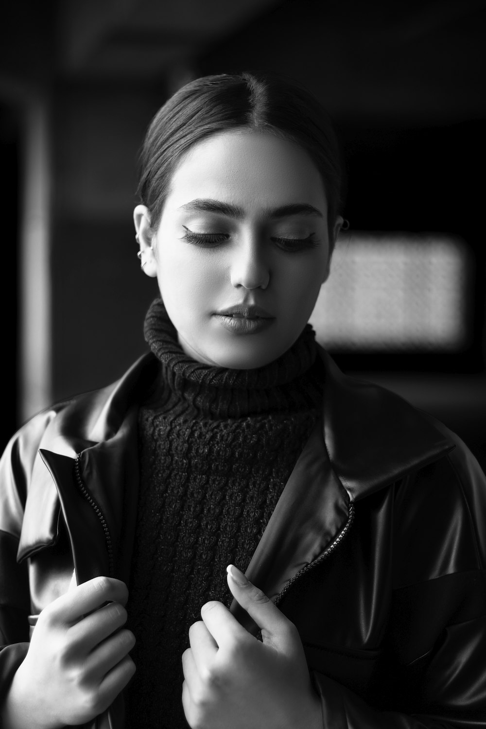 a woman in a leather jacket is looking down