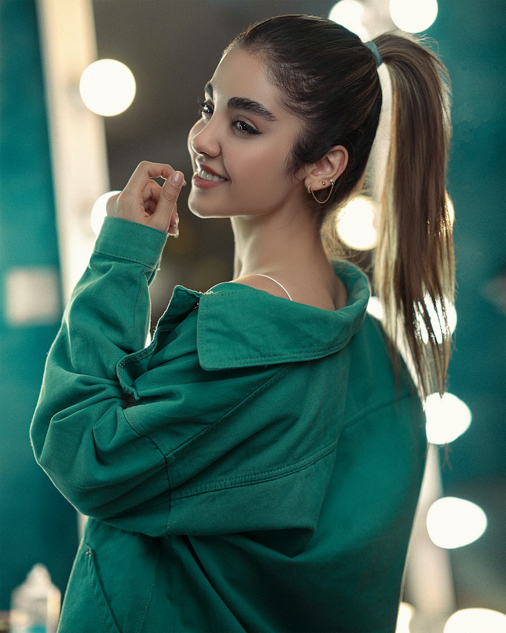 a woman with a ponytail standing in front of a mirror