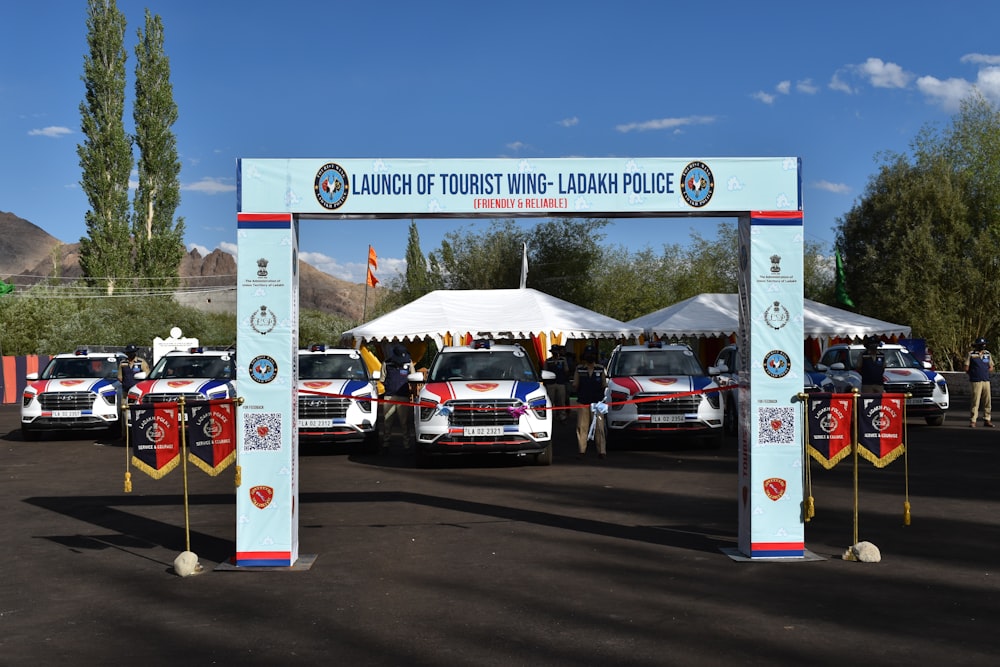 a group of cars parked under a white tent