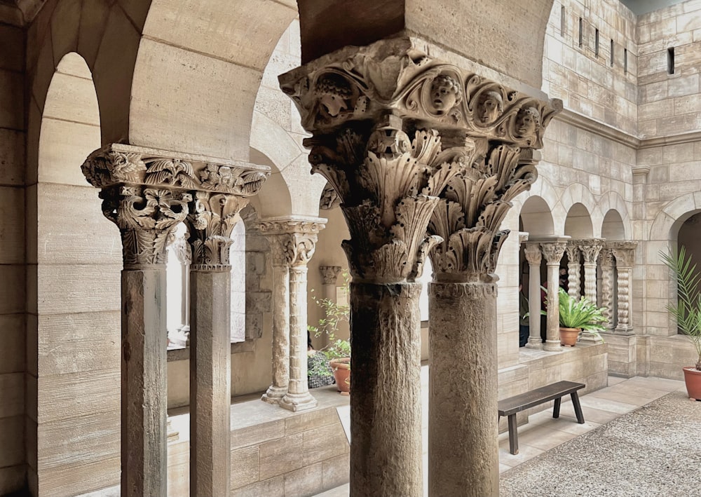 a stone building with columns and a bench