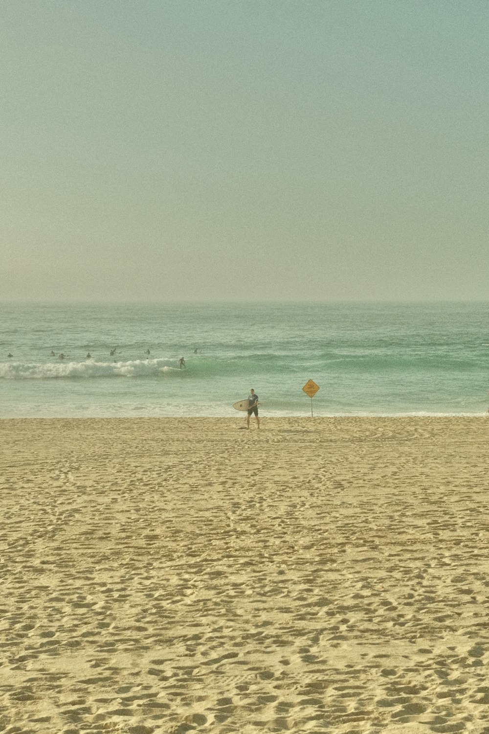 a person standing on a beach with a surfboard