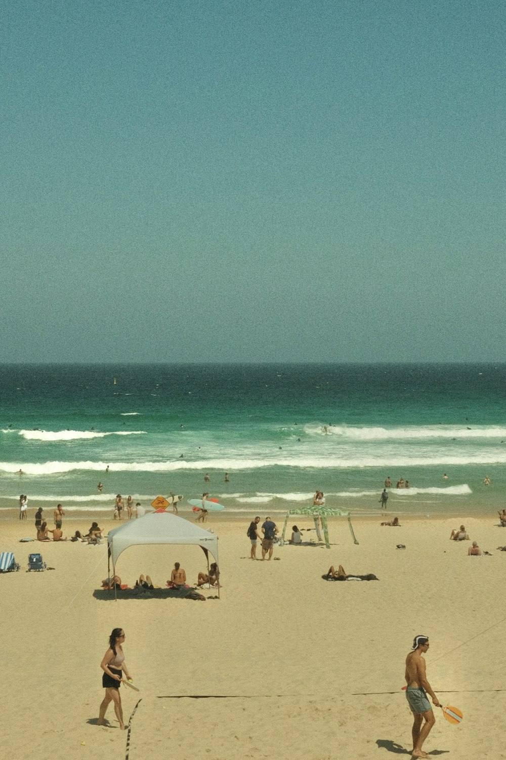 a group of people on a beach near the ocean