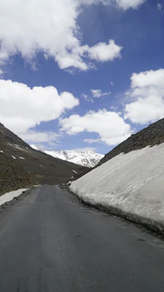 A winding road climbing Independence Pass, framed by towering cliffs and patches of snow.