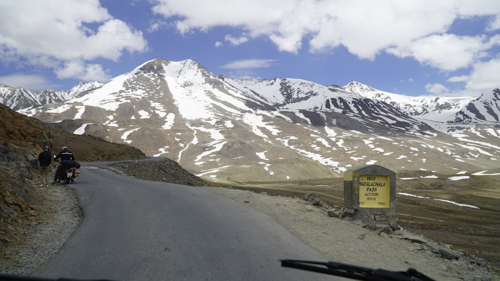 two people riding motorcycles down a mountain road