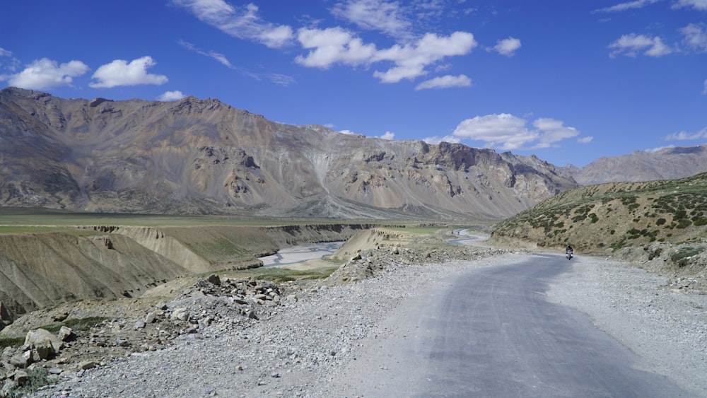 a person riding a motorcycle down a gravel road