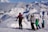 a group of people riding skis on top of a snow covered slope