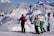 a group of people riding skis on top of a snow covered slope