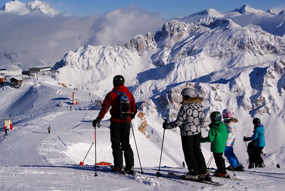 a group of people riding skis on top of a snow covered slope