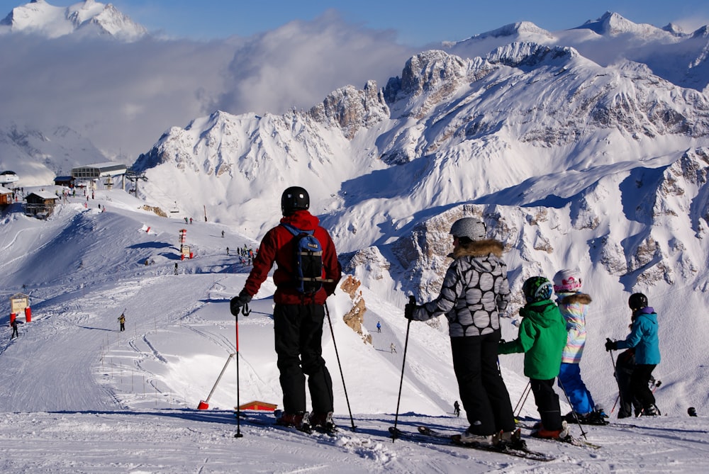 雪に覆われた斜面の上でスキーに乗る人々のグループ