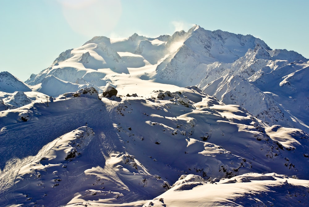 a large mountain covered in snow under a blue sky