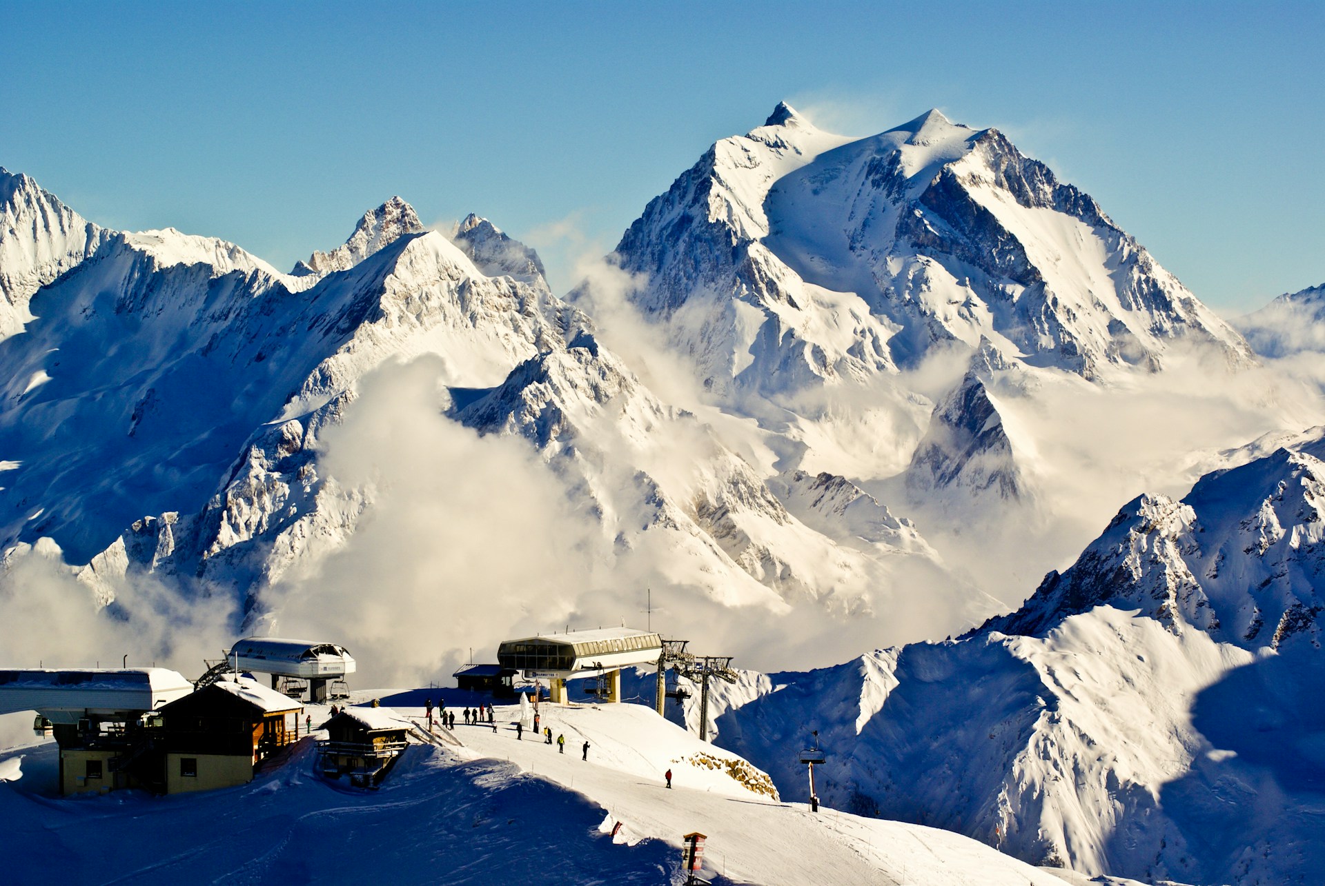 a snow covered mountain with a ski lift in the distance