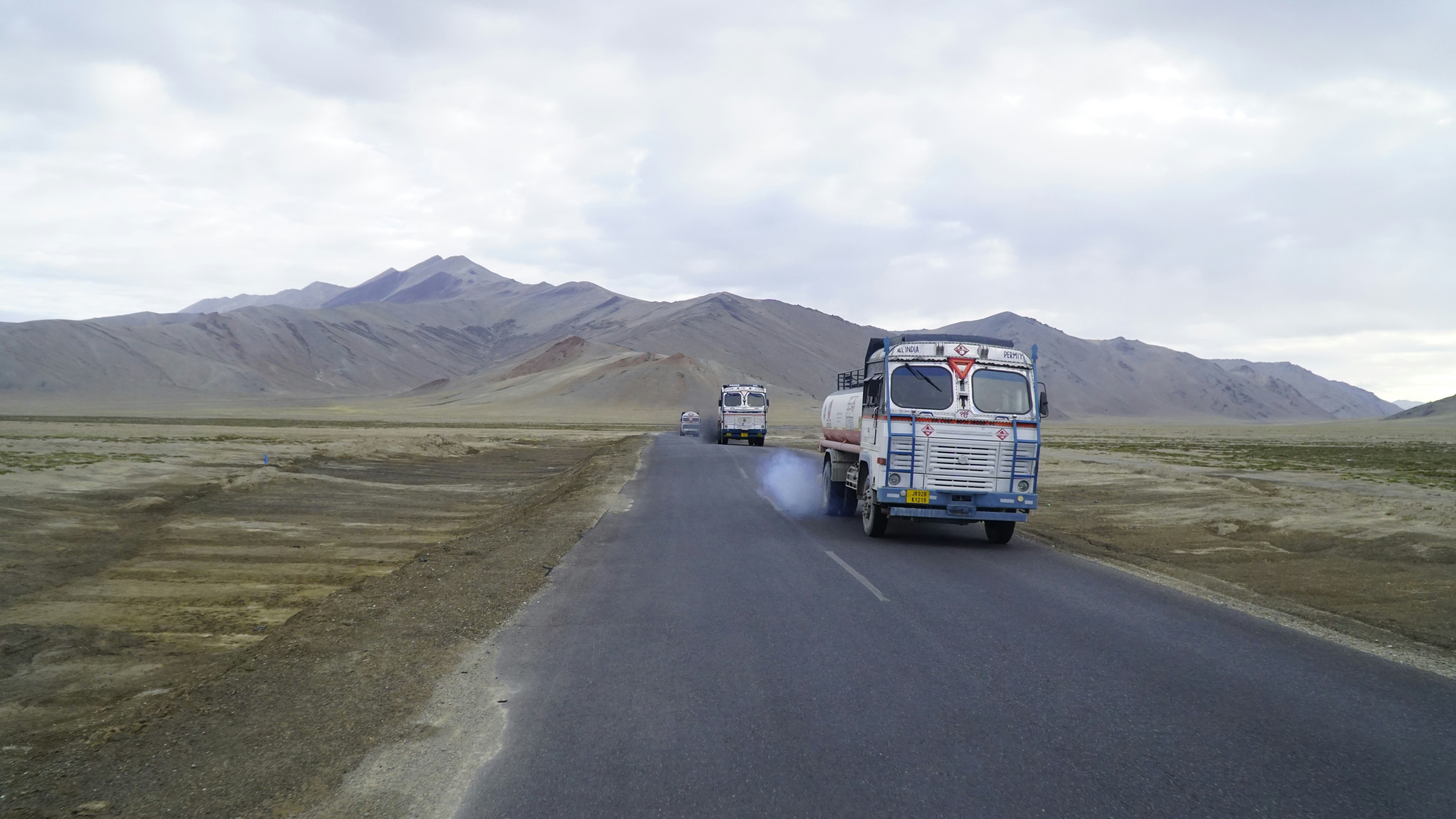 a couple of trucks driving down a road