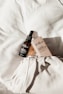 A bottle of Evelia Chilean Rose Hip Oil with a dropper sits atop a textured white fabric surface, alongside its packaging box. The items are positioned to capture natural light, creating soft shadows and highlighting the elegant presentation.