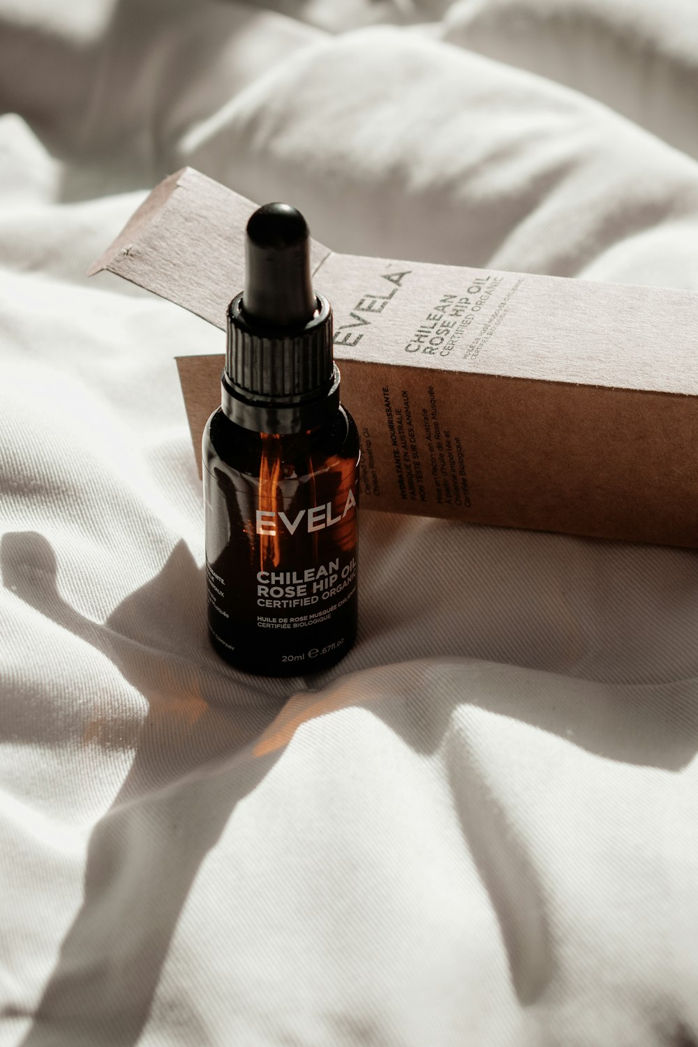 a bottle of essential oil sitting on a bed