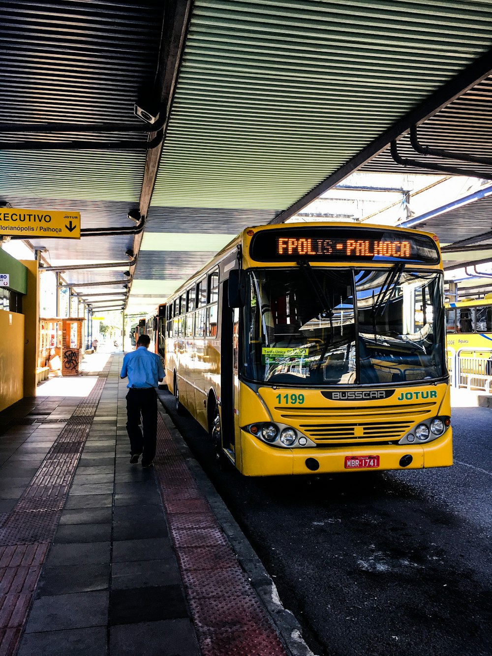 a yellow bus parked at a bus station