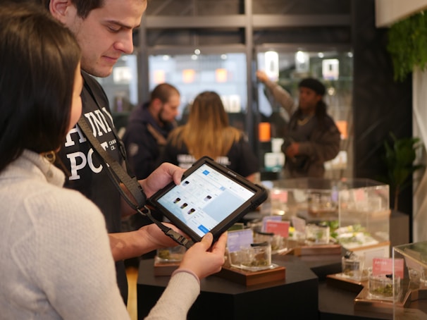 A friendly user interacting with the Catalog Creator app on a tablet, surrounded by auction items.