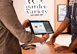 a man holding a tablet while standing next to another man