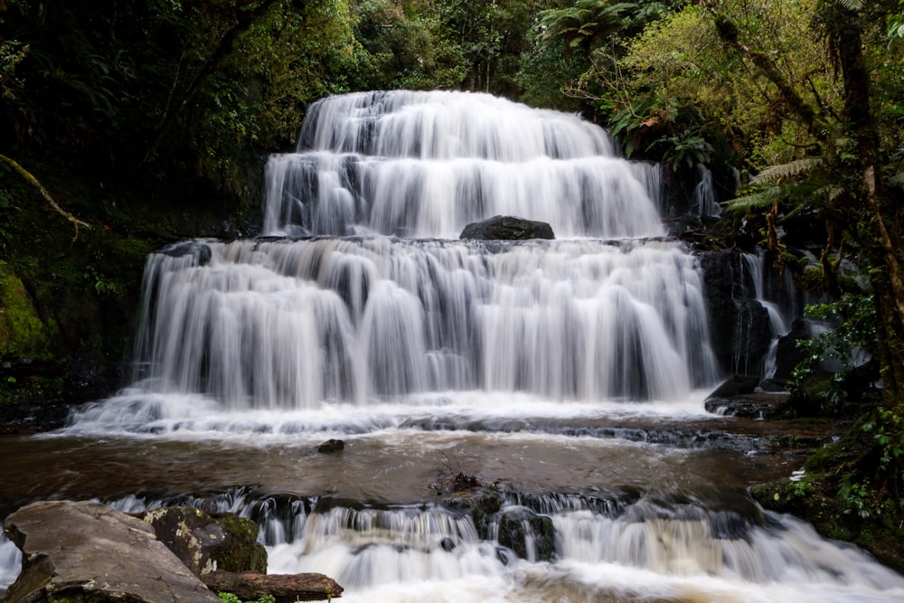 a large waterfall in the middle of a forest