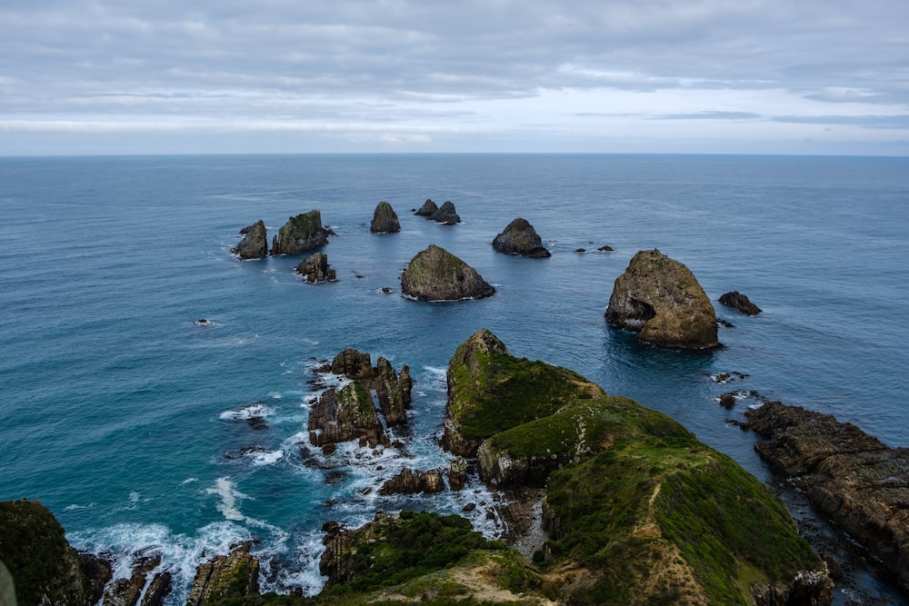 a group of rocks sitting on top of a lush green hillside