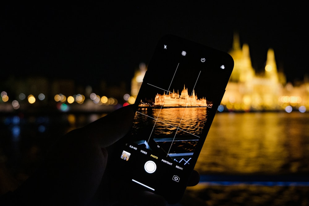 a person taking a picture of a city at night