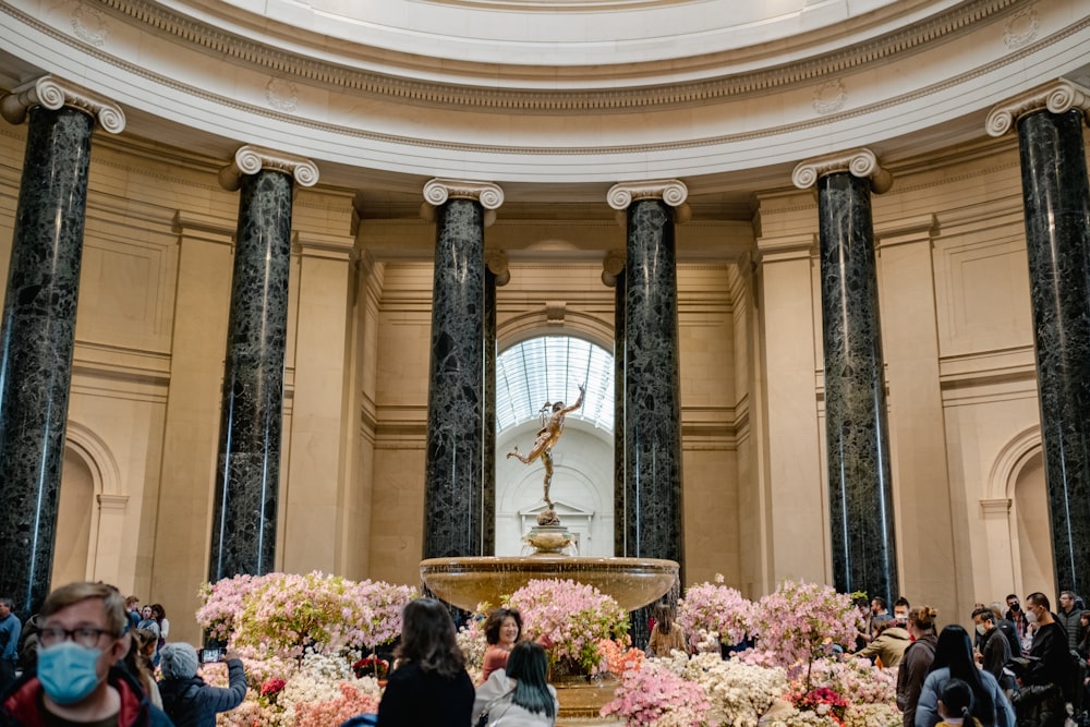 a group of people standing around a fountain in a building