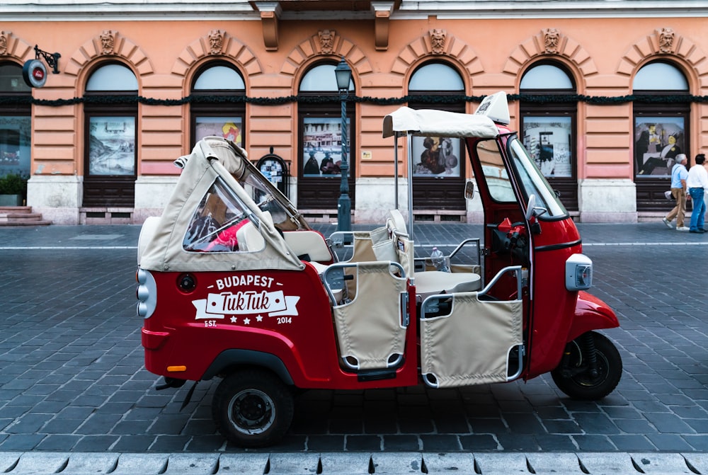 a small red and white car parked in front of a building