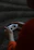 Close-up of a gamer’s hands gripping a controller with a dark-themed gaming setup in the background.