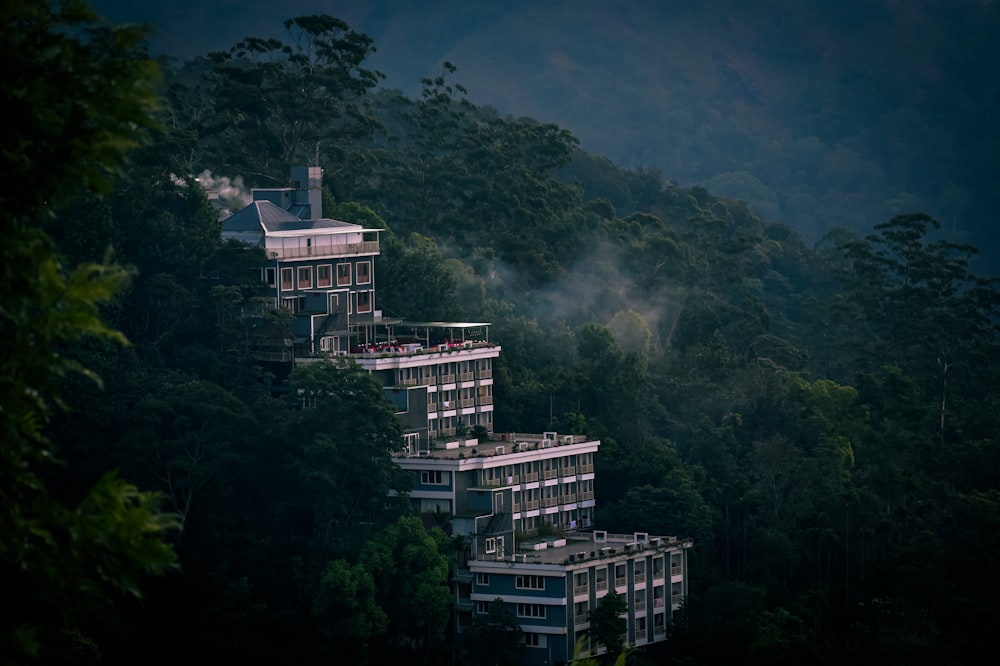 a group of tall buildings sitting on top of a lush green forest