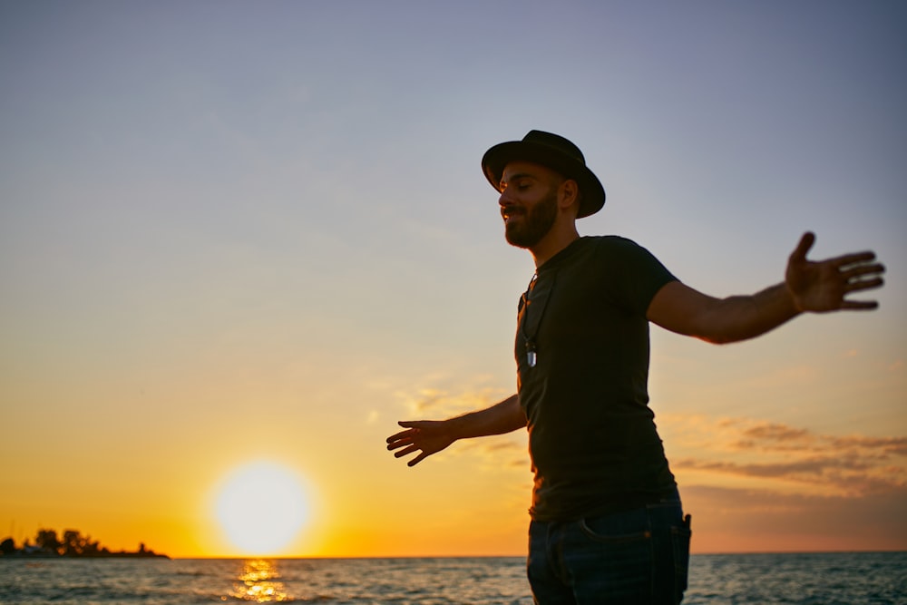 a man standing on top of a beach next to the ocean