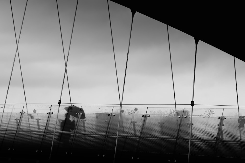 a person standing on a bridge holding an umbrella