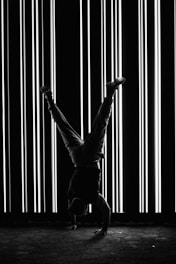 a man doing a handstand in front of a wall of lights