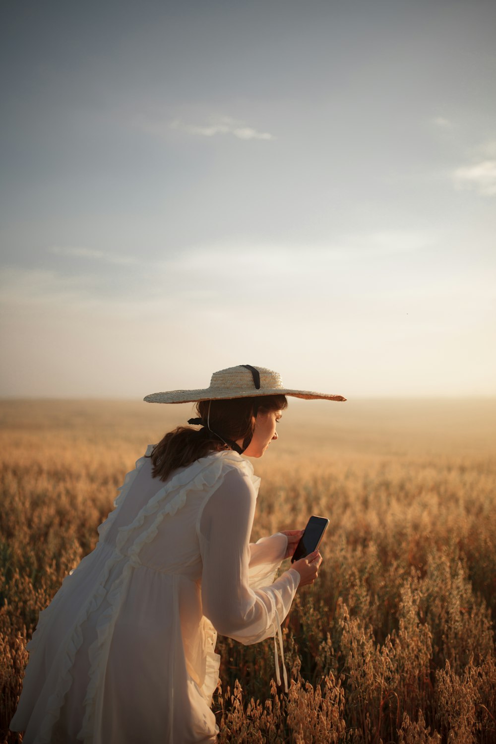 a woman standing in a field with a cell phone