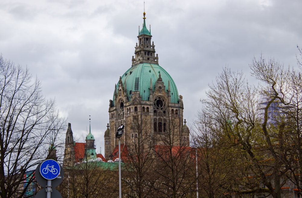 ein großes Gebäude mit einem grünen Dach und einer blauen Kuppel