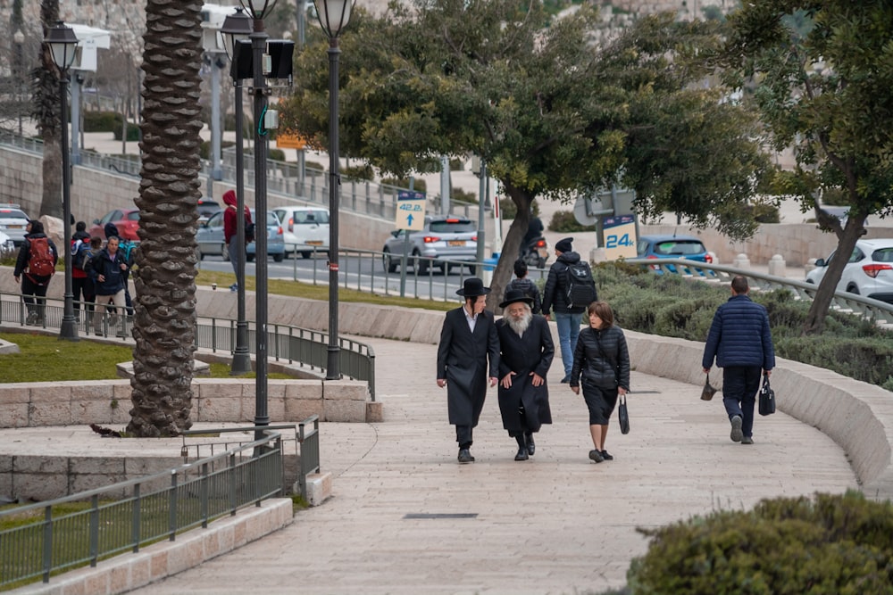 a group of people walking down a sidewalk