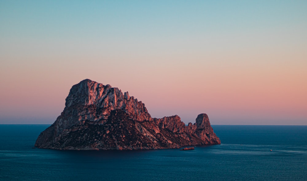 a large rock formation in the middle of the ocean