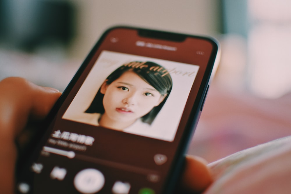 a person holding a cell phone with a picture of a woman on it