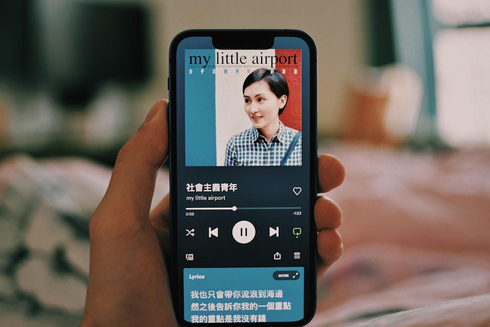 a person holding a cell phone with a picture of a woman on the screen