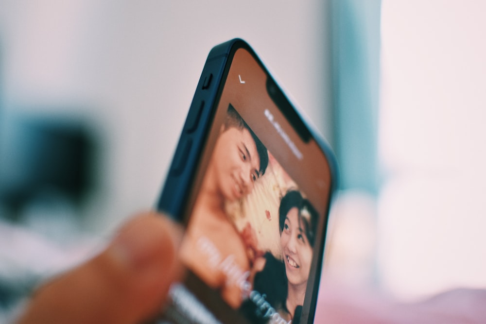 a close up of a person holding a cell phone