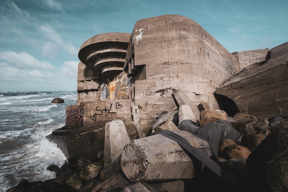 a concrete structure sitting on top of a beach next to the ocean