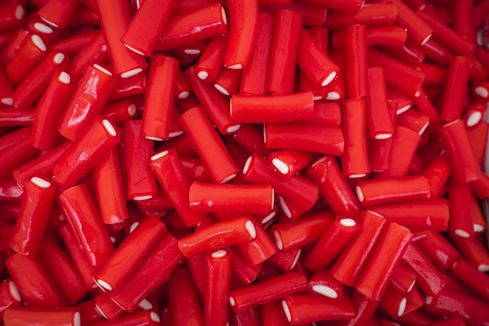 a pile of red candy canes with white sprinkles