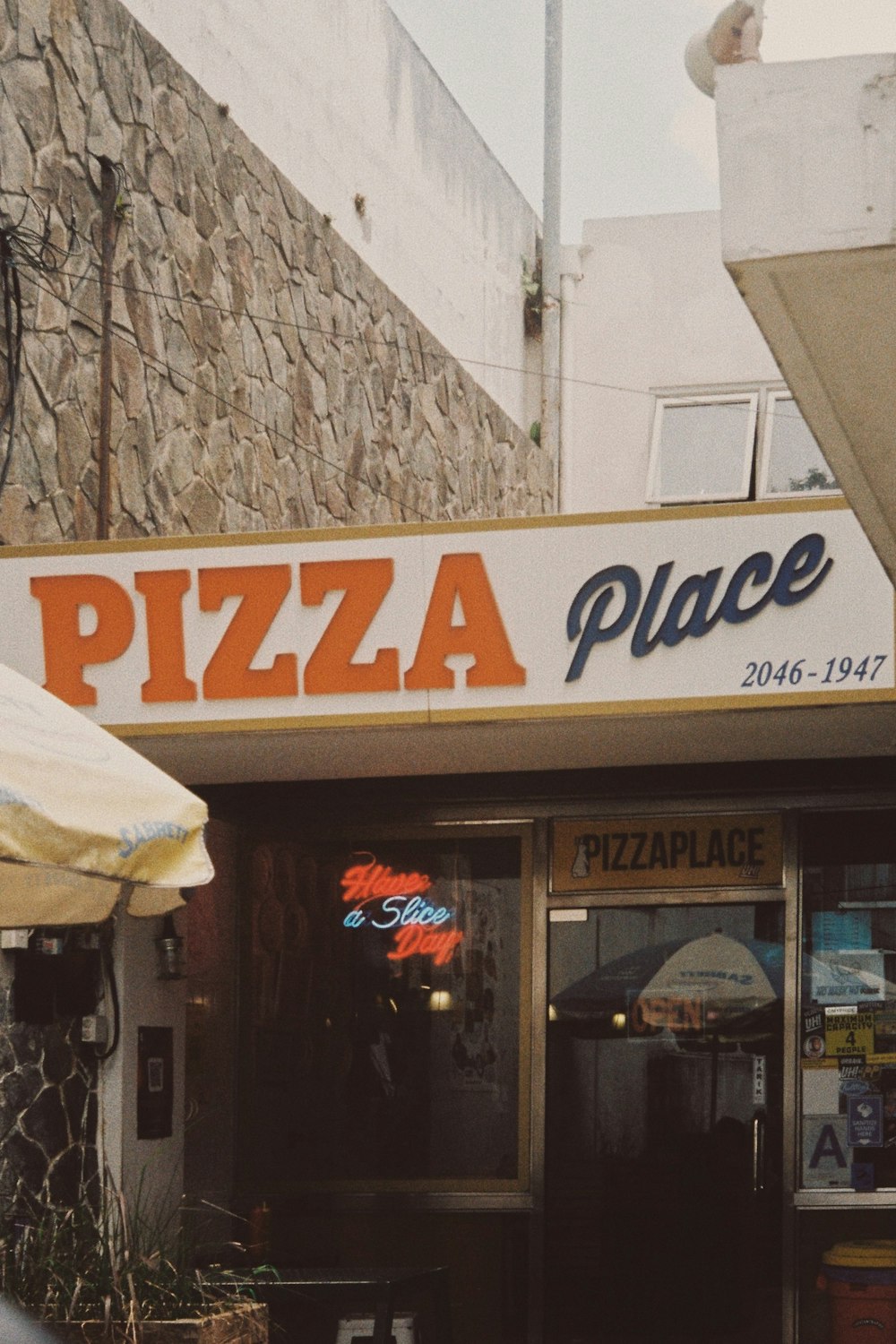 a pizza place with a large sign above it