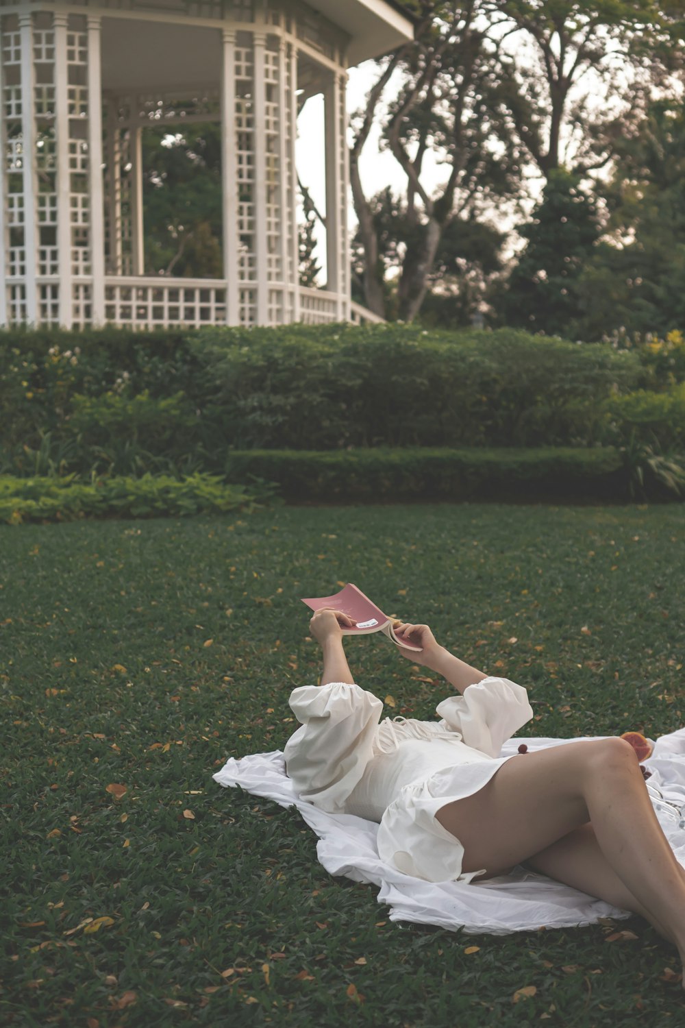 a woman in a white dress laying on the grass